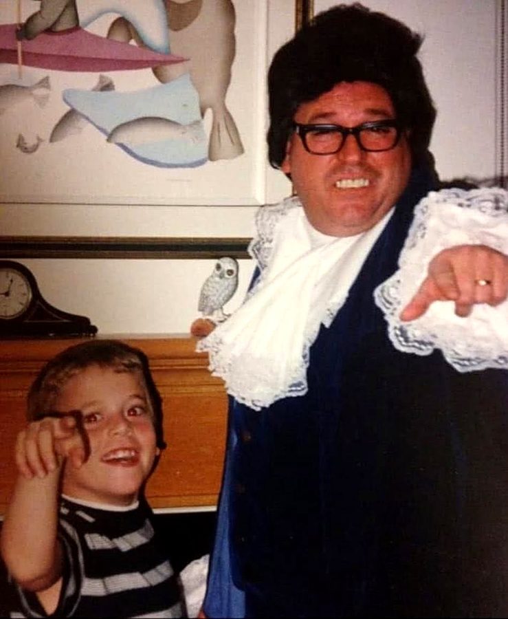 Ron dressed as Austin Powers for Halloween, a young son pointing at the camera beside him