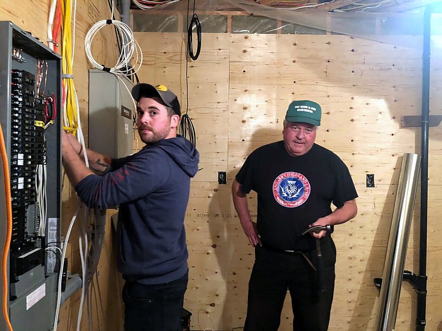 Ron and a younger man wiring the electrical panel