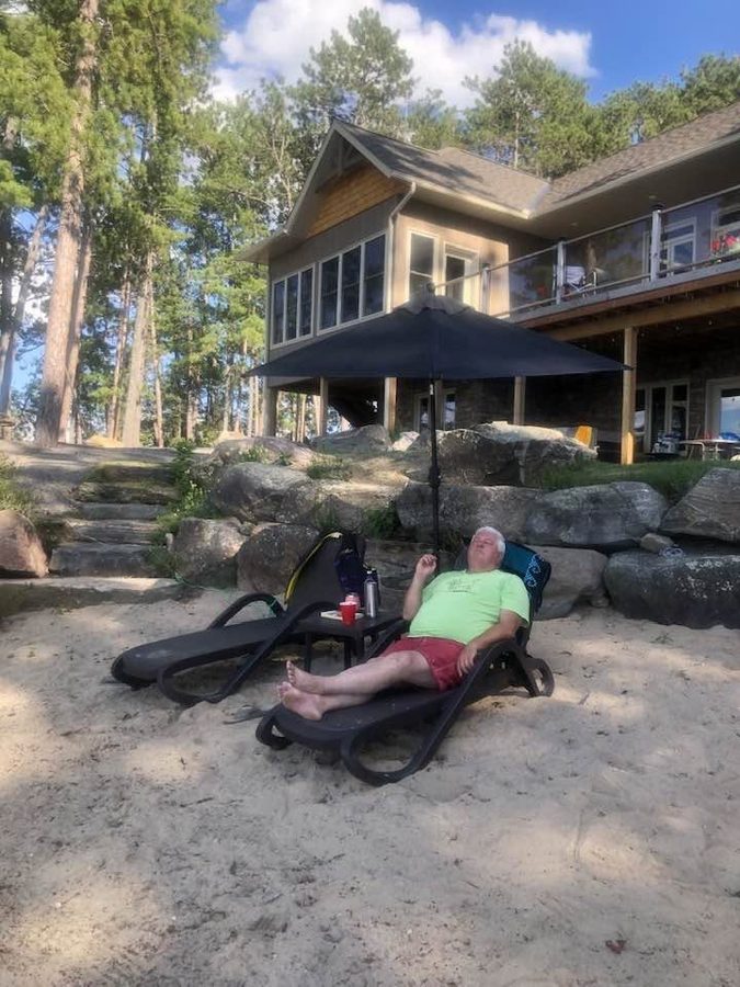 Ron resting on the beach below the finished house