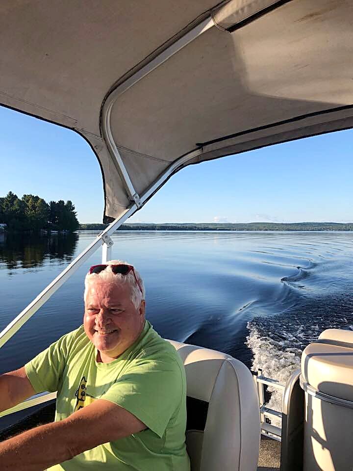 Ron at the wheel of the pontoon boat on Round Lake