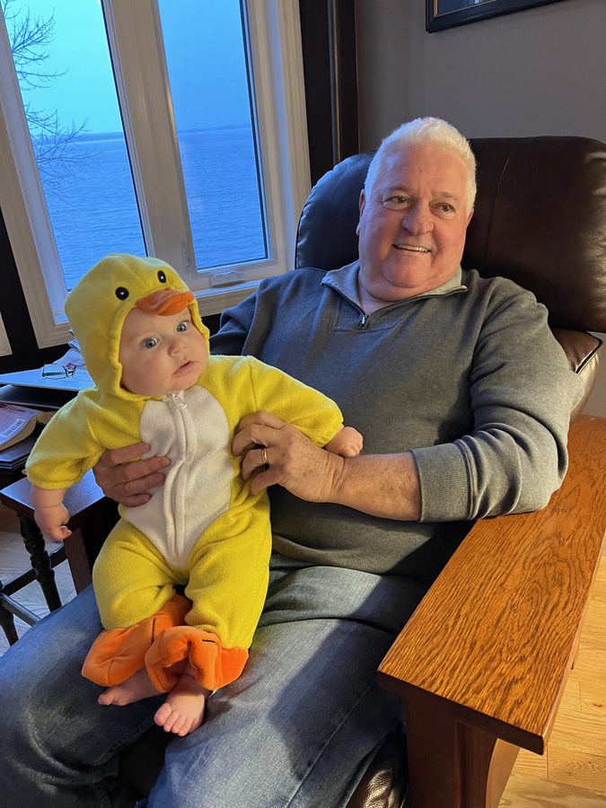 Ron holding a grandson dressed in a duck costume