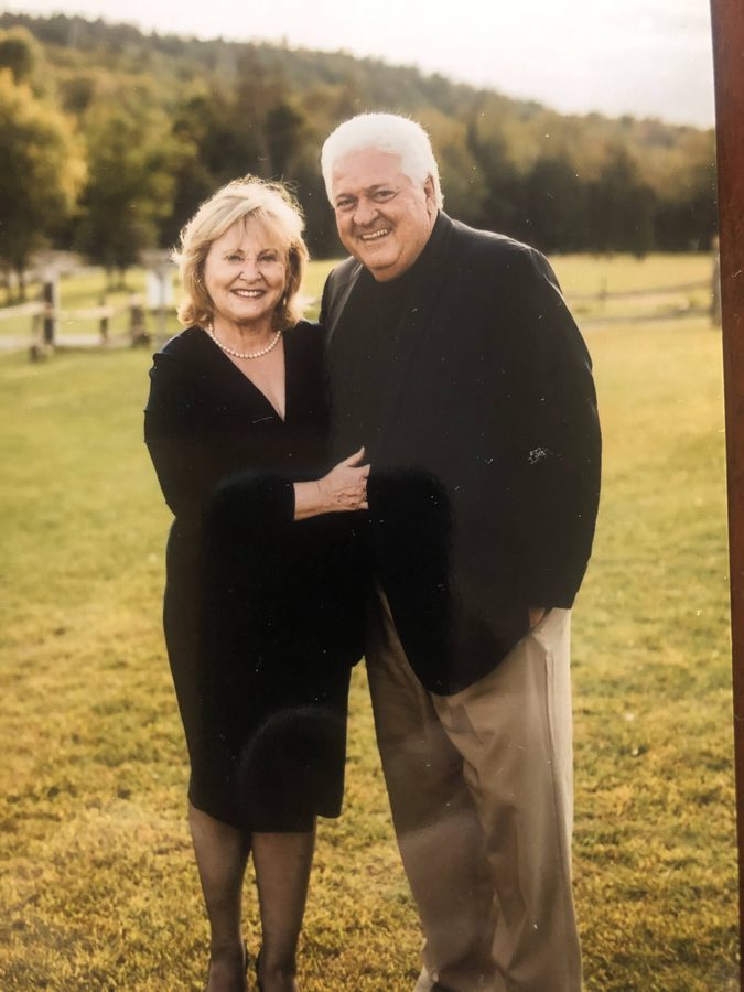 Ron and Annadeane dressed up, a field and hills behind them