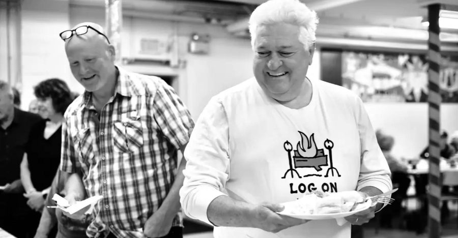 Ron carrying a plate of food, laughing